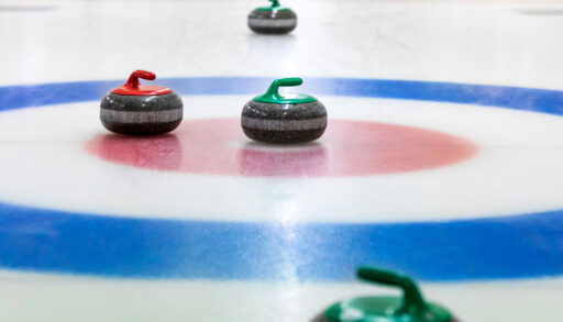 Red and green curling stones in the blue and red rings.