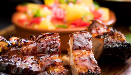 Close-up of cooked pork ribs covered in sauce.