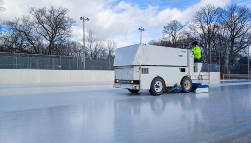 White Zamboni cleaning ice rink.