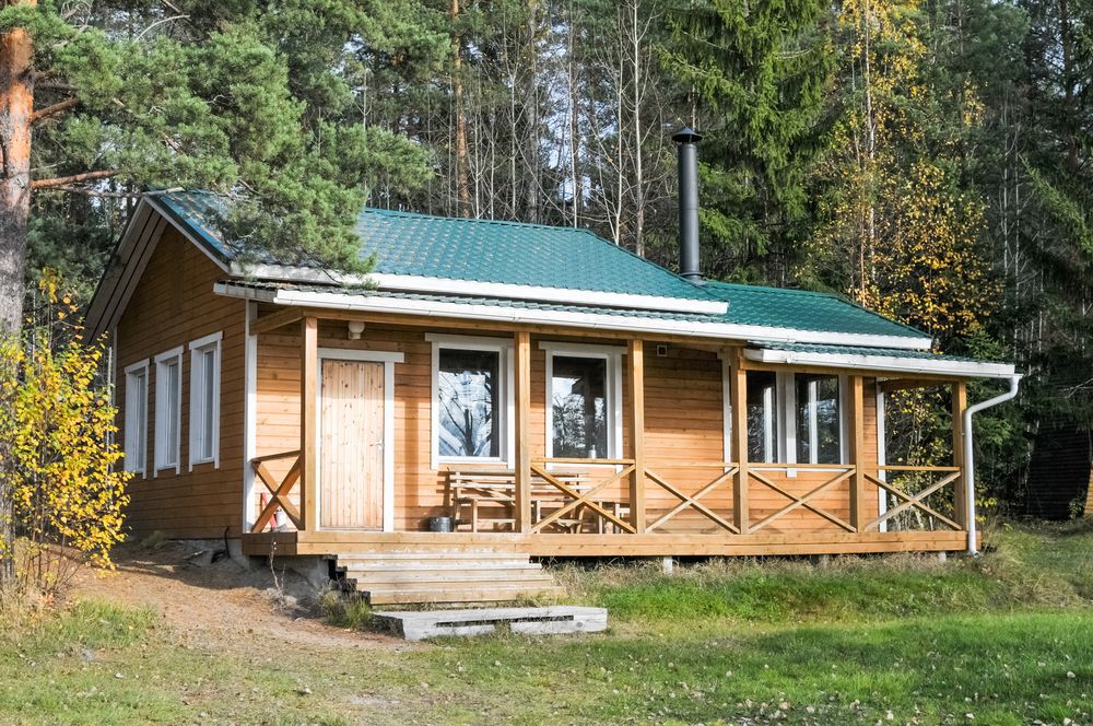 Remote wooden cabin with a green metal roof.
