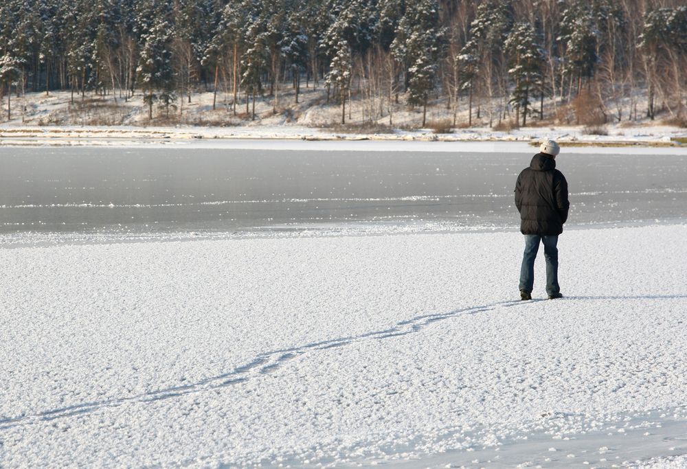 Person in a black jacket walking on thin ice.