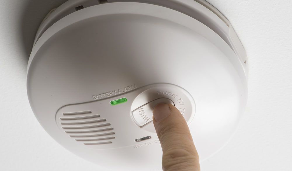 Person testing their smoke detector.