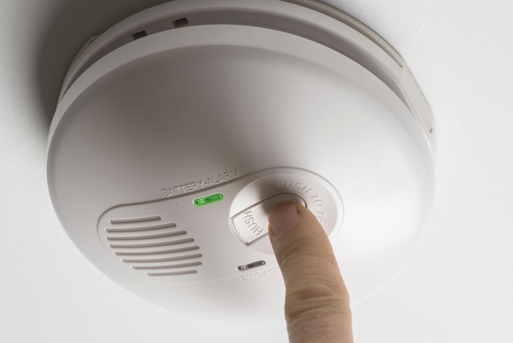 Person testing their smoke detector.