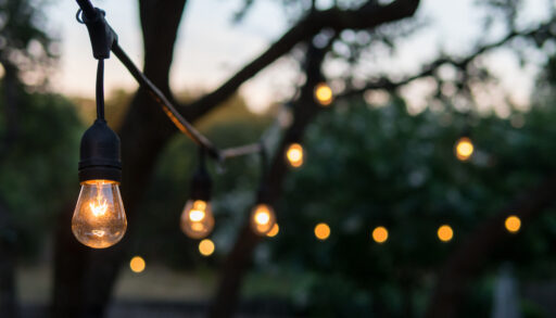 Decorative outdoor lights lit up at dusk.
