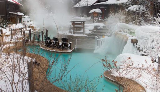 Outdoor hot springs spa covered in snow.