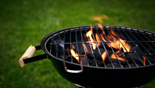 Black circular grill in a backyard.