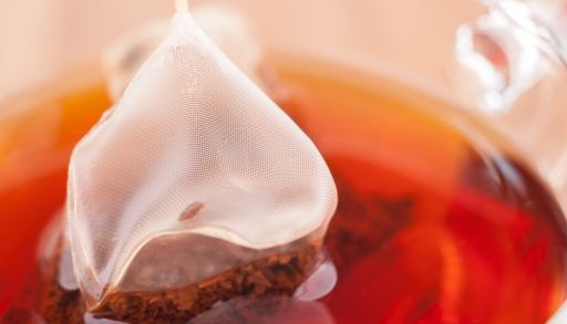 Mesh tea bag steeping in hot water.