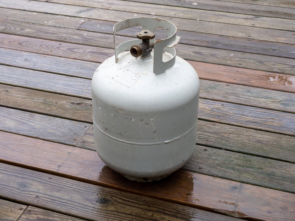 Propane tank on a wooden deck.