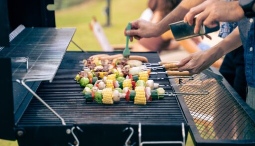 Close-up of people barbecuing food at a party.