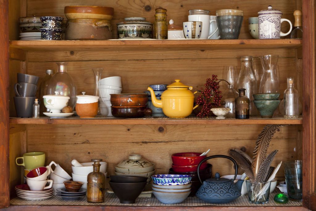Ceramic kitchen equipment on wooden shelves.