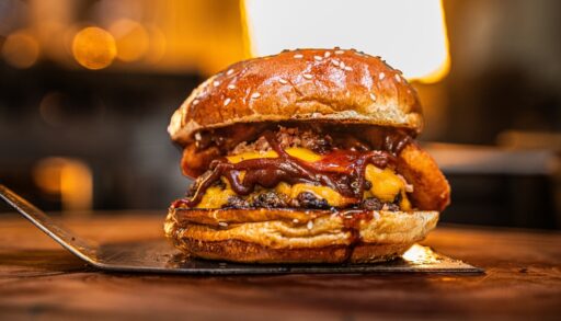 Smash burger loaded with irresistible toppings on a wooden board.
