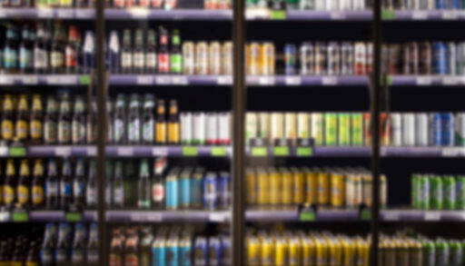 Blurred image of alcoholic beverages in cooler at liquor store.