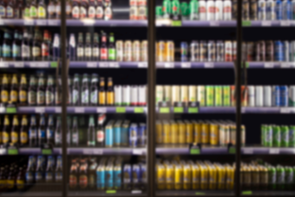 Blurred image of alcoholic beverages in cooler at liquor store.