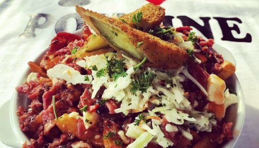 Poutine with deep fried pickles, with an "I heart poutine" shirt in the background