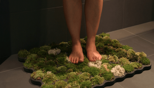 Person's feet on moss bath mat