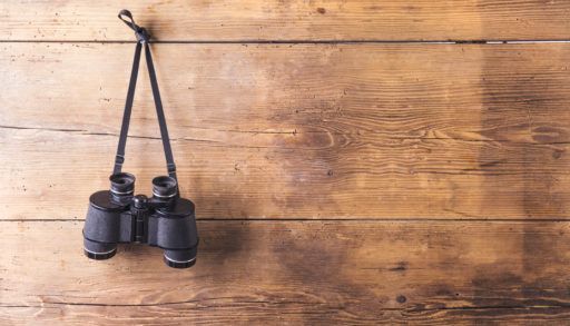 binoculars-hung-up-on-a-hook-on-wooden-wall