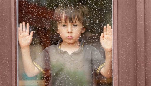 bored-kid-looking-out-rainy-window