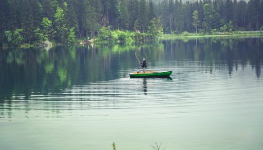 Fisher in boat on lake