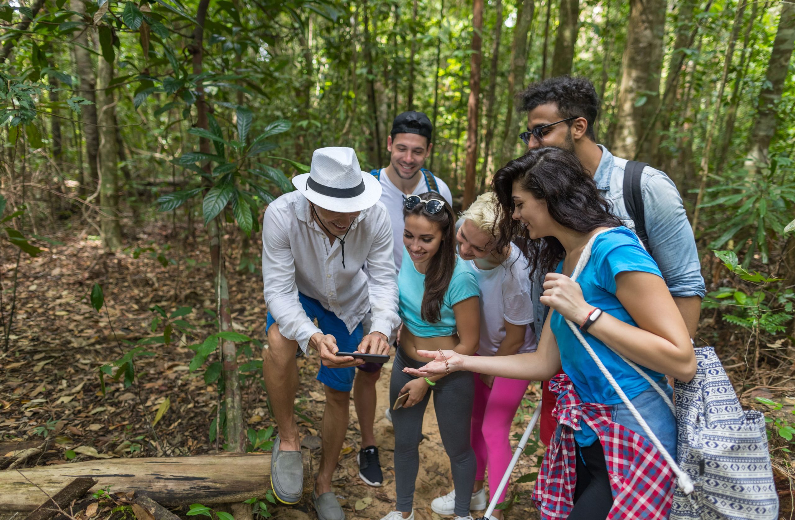 A-group-of-young-people-looking-at-a-map-in-the-woods