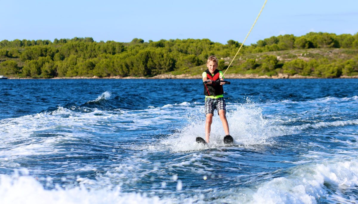 young-boy-waterskiing-on-lake