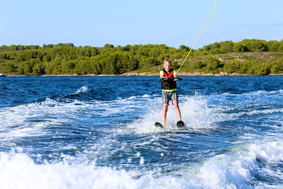 young-boy-waterskiing-on-lake