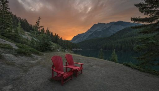 Red chairs at Two Jack Lake in Banff National Park, Canada