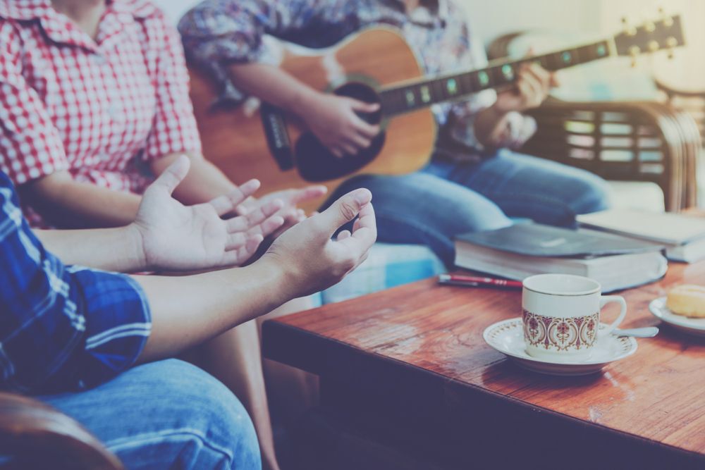 Small group of people talk and play guitar
