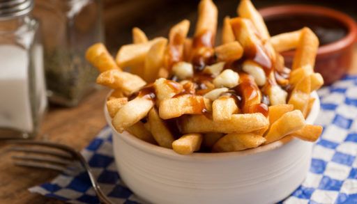 A bowl of poutine on a clue checkered napkin