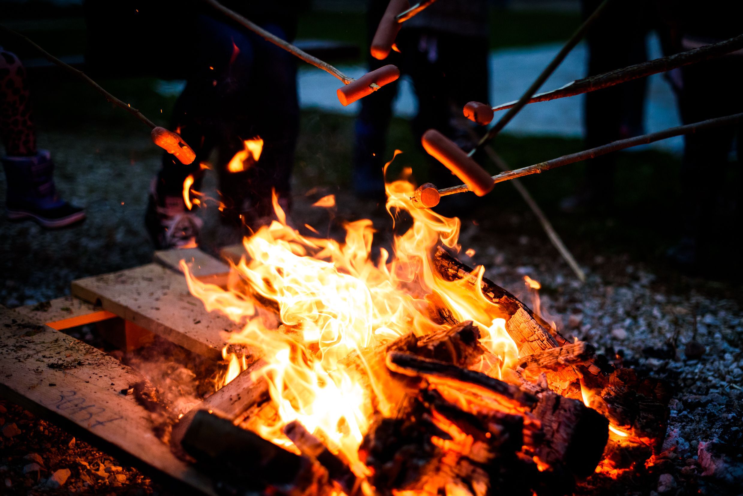 Making and cooking hot dogs over open camp fire