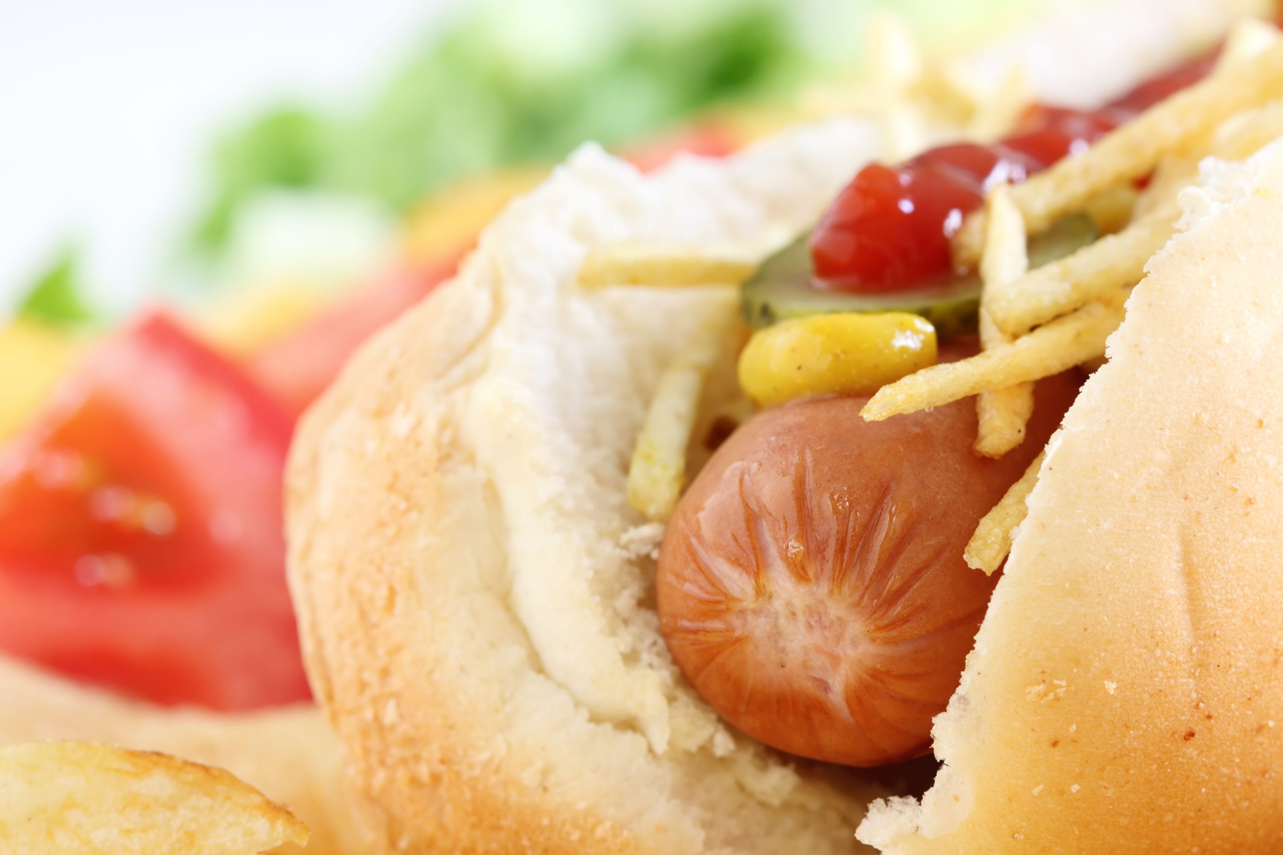 Close up of a hot dog with vegetables