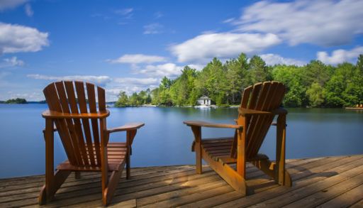 Two-Muskoka-chairs-on-a-dock-by-a-lake