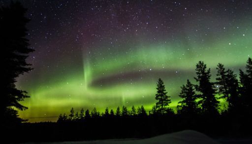 Green northern lights illuminate the night sky