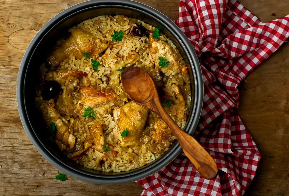 A photo of a crock pot with chicken and rice in it