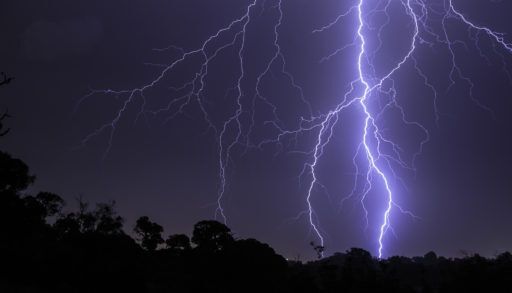 Dark night sky with lightning streaking across it