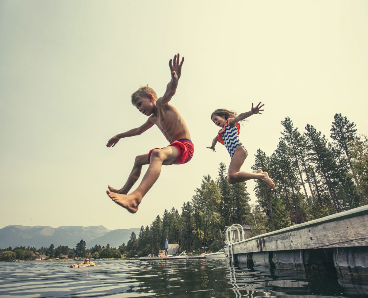 Kids jumping into the lake off the dock