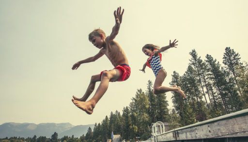 Kids jumping into the lake off the dock