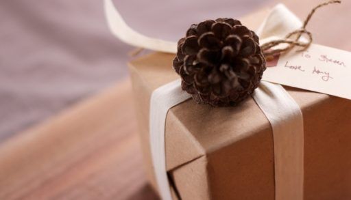 A gift decorated with a pine cone and ribbon