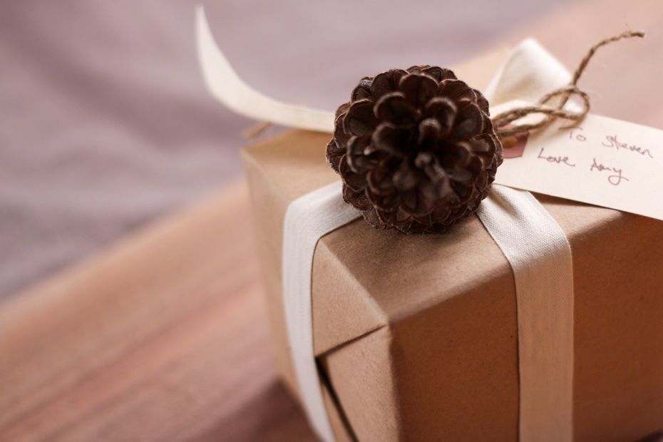 A gift decorated with a pine cone and ribbon
