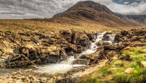 Rocky and grassy Tablelands waterfall in Newfoundland, Canada