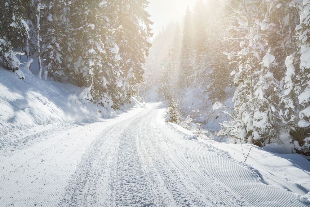 An empty snow covered road in the sun