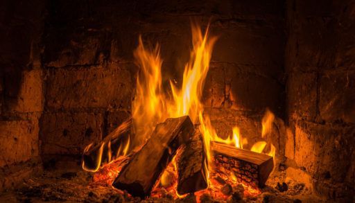wooden logs burning in a fireplace