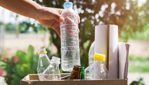 hand putting recycling into cardboard box