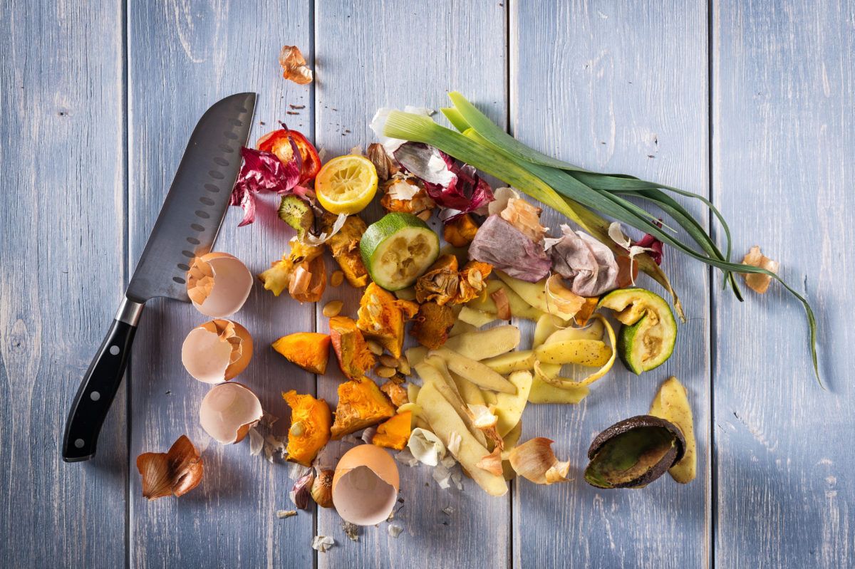 organic-kitchen-scraps-waste-from-vegetables-with-a-knife-on-a-wood-background