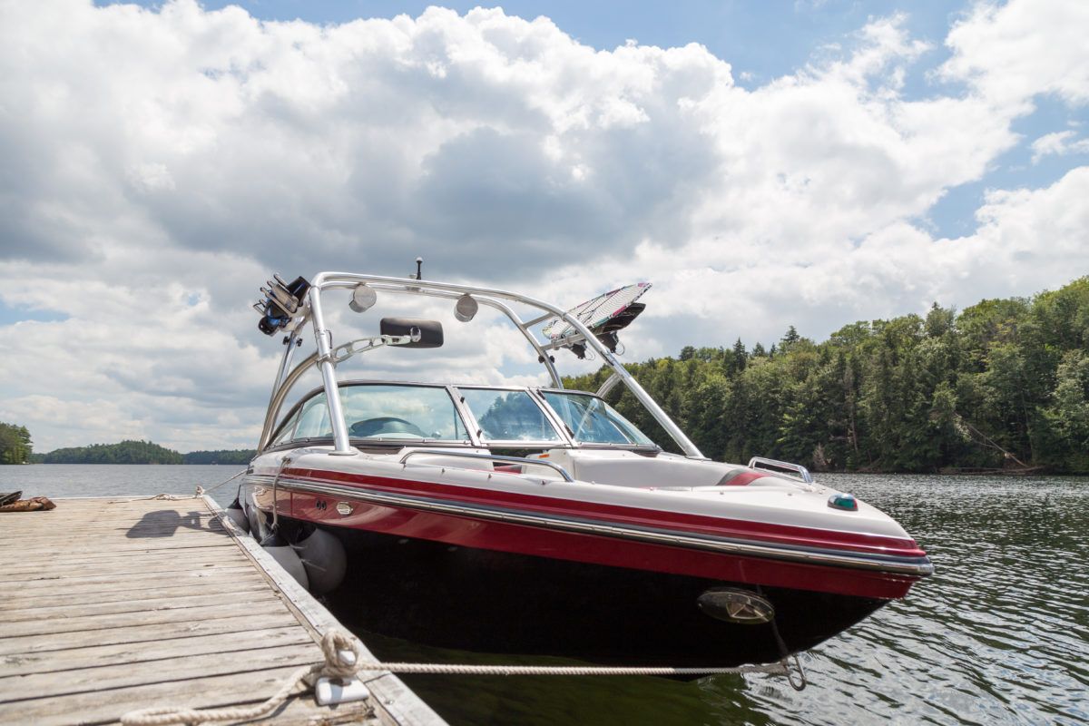 a-wakeboard-boat-at-a-wooden-dock-on-a-sunny-day