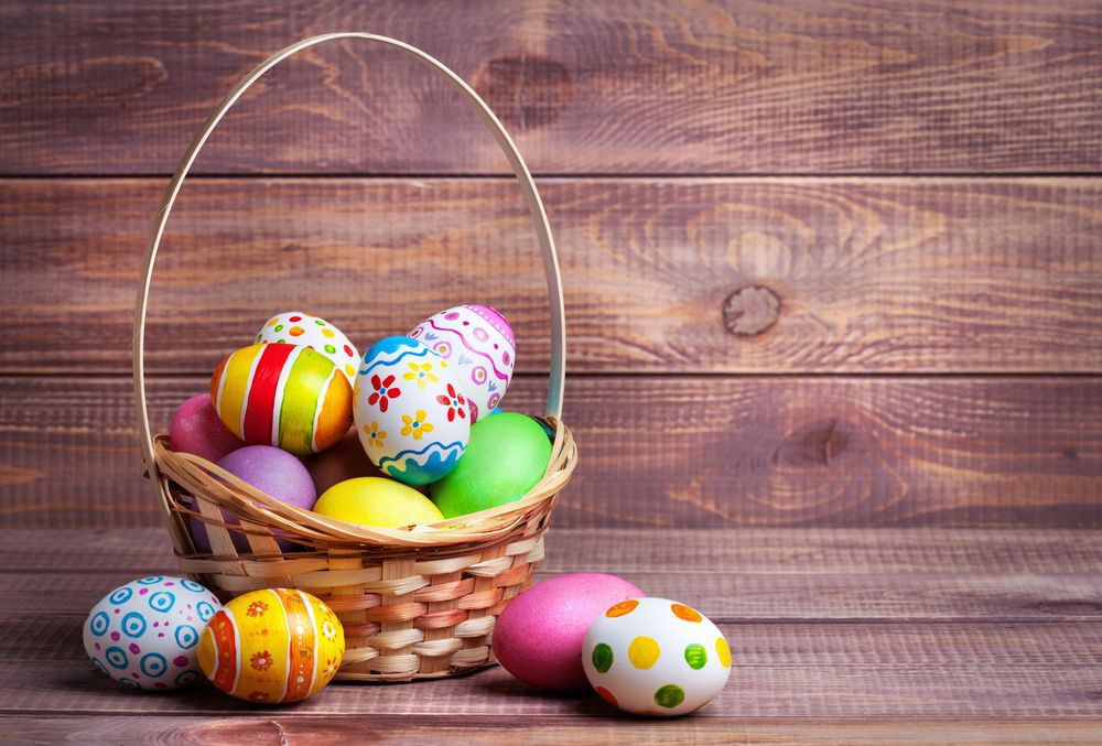easter-eggs-in-a-basket-wooden-background