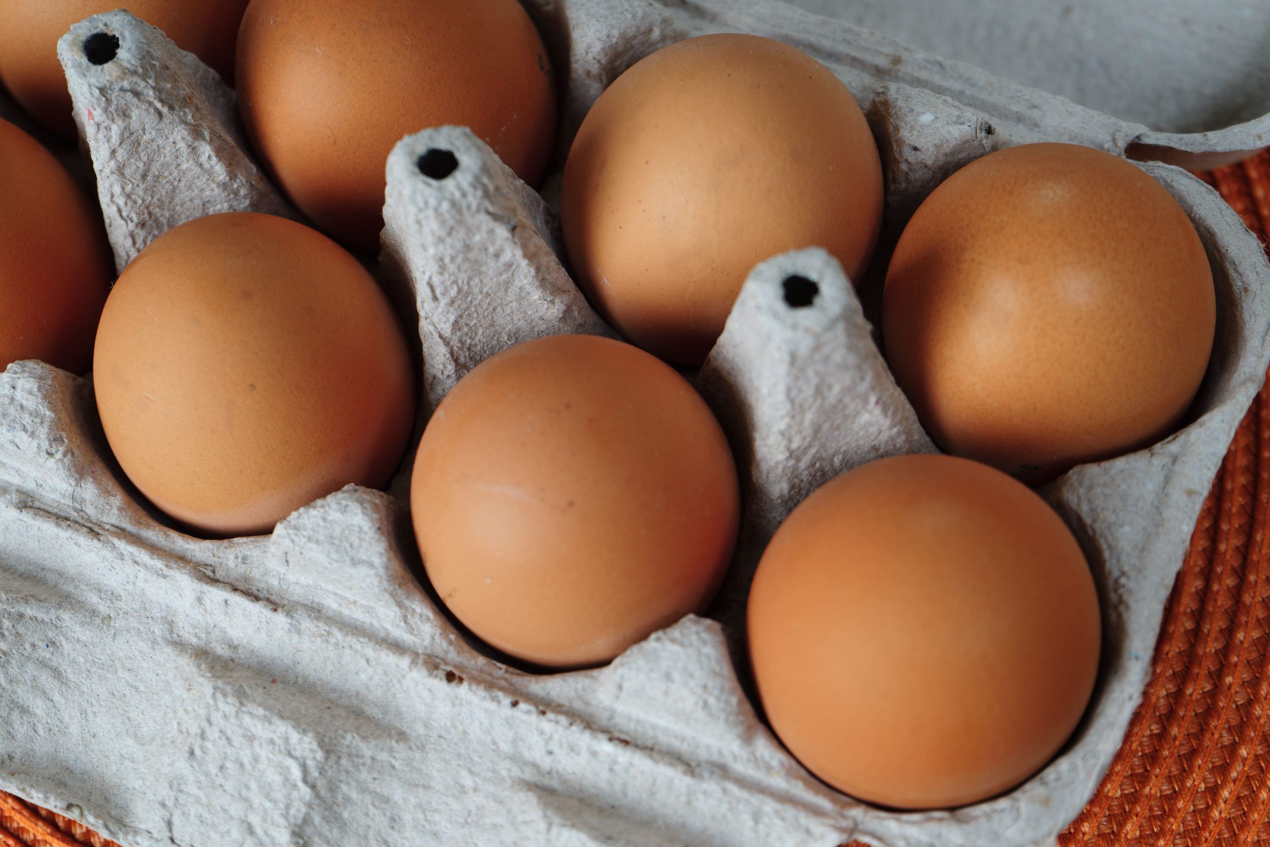 Fresh-brown-eggs-with-yolk-on-cardboard-tray