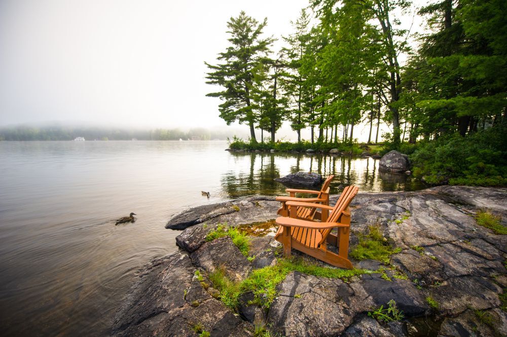Two cottage chairs on a rocky lakeshore