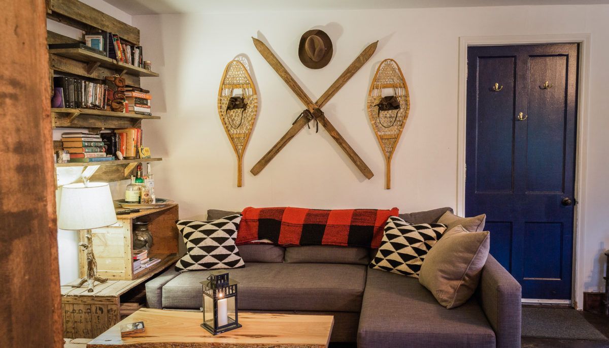 rustic short-term rental living room with snowshoes and skis on the wall
