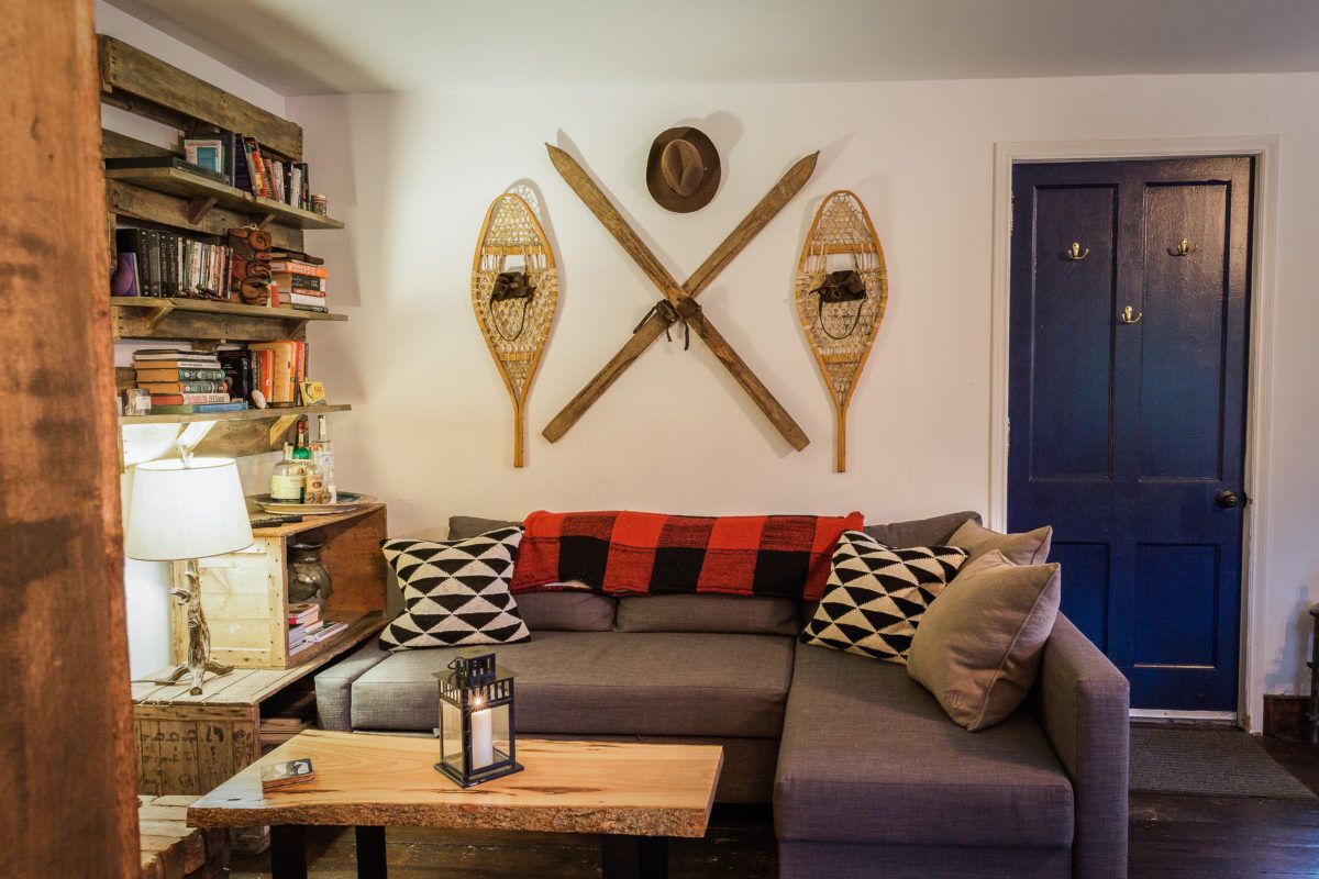 rustic short-term rental living room with snowshoes and skis on the wall