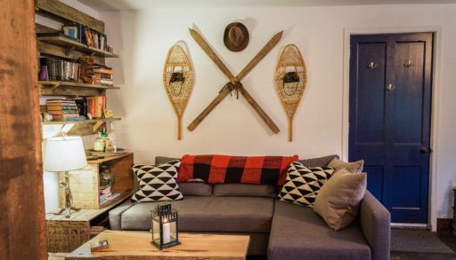 rustic short-term rental living room with snowshoes and skis on the wall